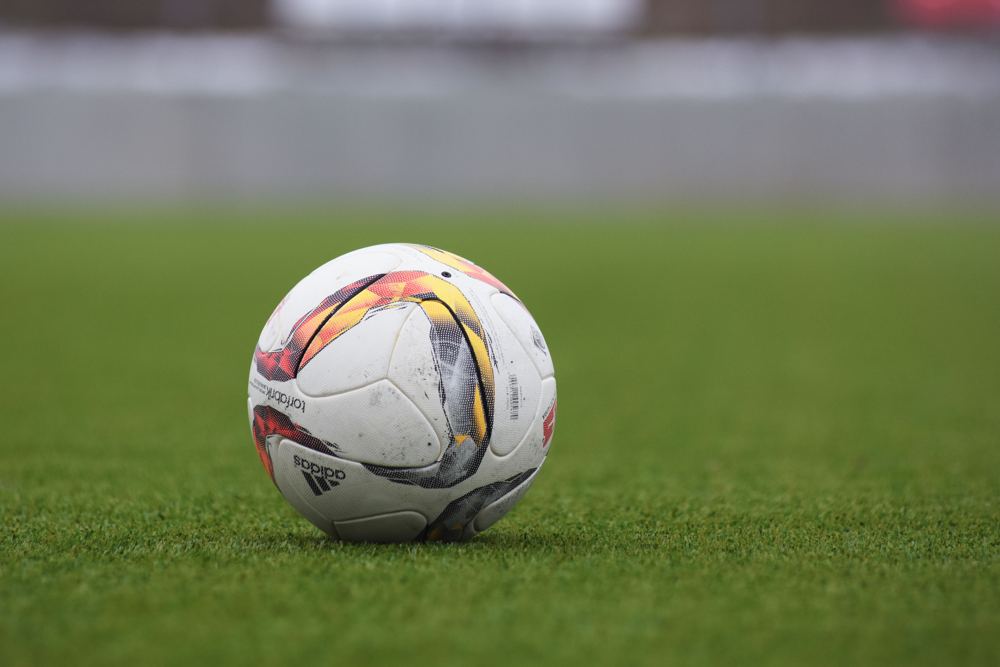 Sfeerfoto van een voetbal op een groen grasveld